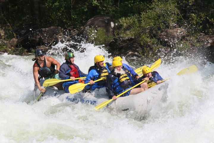 a group of people riding skis on a raft in the water