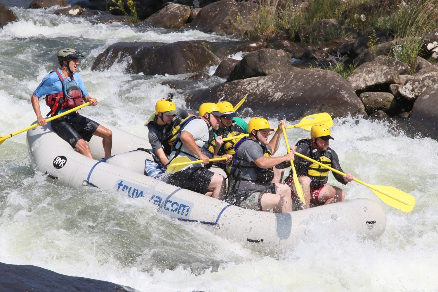 a group of people riding skis on a raft in a body of water