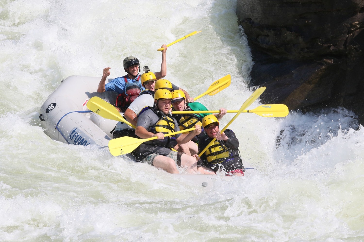 a man riding a wave on a raft in a body of water